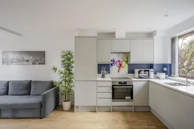 a living room with a couch and a kitchen at Modern Apartment in Chelmsford City, Free WiFi & Free Parking - Dukes Apartment by Stays Accommodation - Long Stays Welcome in Chelmsford