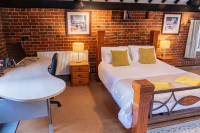 a bedroom with a bed and a desk and a table at 3 Bed Country House with Pool and Sauna in Tibenham