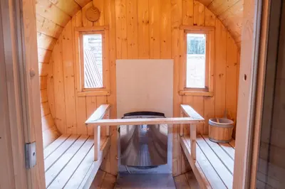 a small room in a wooden cabin with two windows at 3 Bed Country House with Pool and Sauna in Tibenham