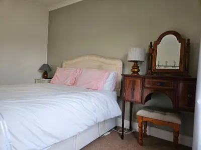 a bedroom with a bed and a dresser and a mirror at B&B Rooms in terraced house in Sudbury centre in Sudbury