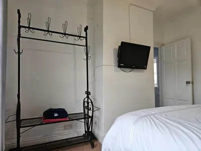 a bedroom with a bed and a tv on the wall at B&B Rooms in terraced house in Sudbury centre in Sudbury