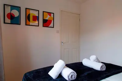 two rolls of towels sitting on top of a bed at Stylish Victorian Terrace in Central Cambridge Pass the Keys in Cambridge