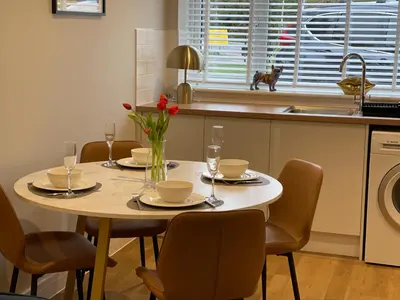 a kitchen with a table with chairs and a sink at Luxury 1 bed new build house near Science & Business parks in Cambridge