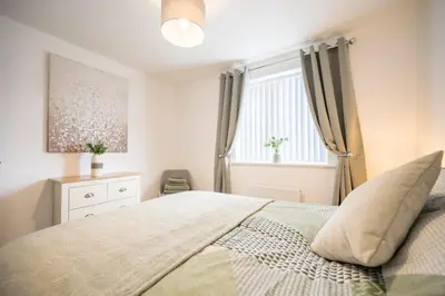a bedroom with a large bed and a window at A Superb 5BR House near SZC in Leiston
