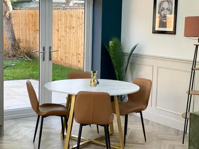 a dining room with a white table and chairs at Luxury 2 bed new-build house near Science & Business parks in Cambridge