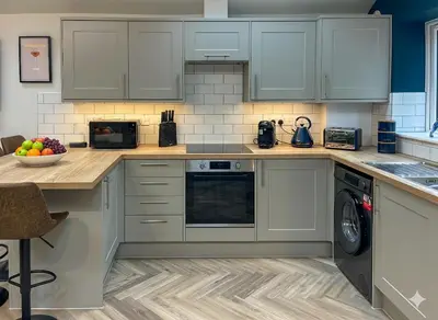 a kitchen with gray cabinets and a dishwasher at Luxury 2 bed new-build house near Science & Business parks in Cambridge