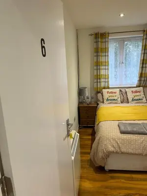 a bedroom with a bed and a window at Maxismile Haven in Southend-on-Sea