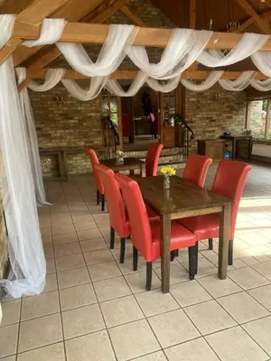a dining room with a wooden table and red chairs at The Golden Boar Inn in Freckenham