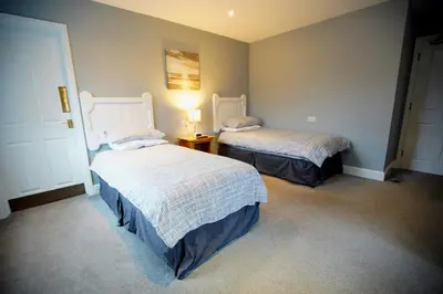 a bedroom with two beds and a lamp on a table at The Golden Boar Inn in Freckenham
