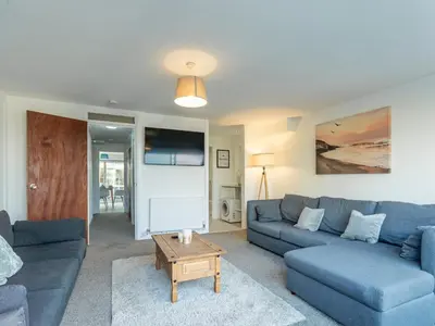 a living room with a blue couch and a table at Pass the Keys Large 4 Bedroom Home Stunning views Contractor in Basildon