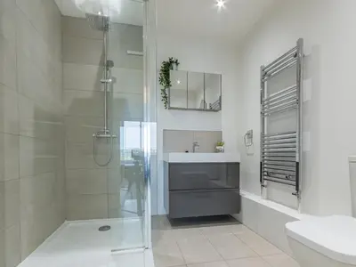 a white bathroom with a shower and a sink at Pass the Keys Large 4 Bedroom Home Stunning views Contractor in Basildon