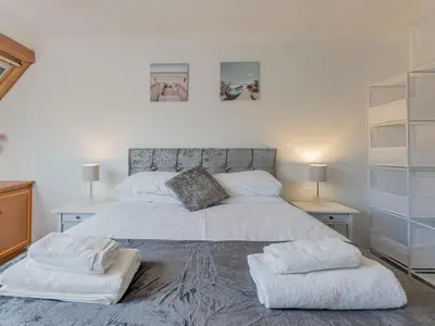 a bedroom with a large white bed with two tables at Pass the Keys Large 4 Bedroom Home Stunning views Contractor in Basildon