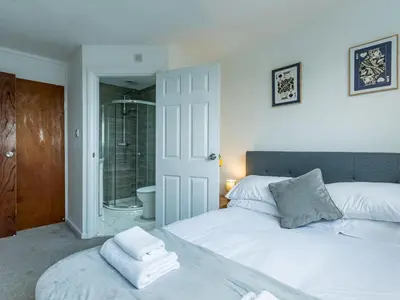 a bedroom with a white bed and a shower at Pass the Keys Large 4 Bedroom Home Stunning views Contractor in Basildon