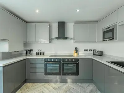 a kitchen with white cabinets and silver appliances at Pass the Keys Large 4 Bedroom Home Stunning views Contractor in Basildon