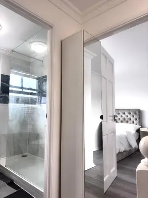 a bathroom with a glass door leading to a bedroom at Ama comfort Stay in Hythe