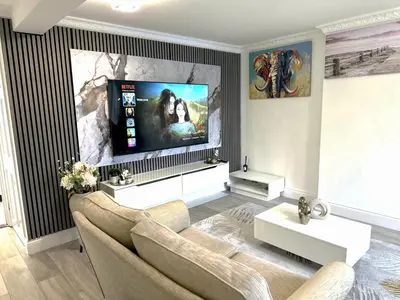 a living room with a couch and a flat screen tv at Ama comfort Stay in Hythe