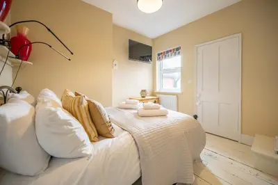 a bedroom with a white bed with pillows and a window at Number 22, Leiston Road, Aldeburgh in Aldeburgh