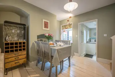 a dining room with a table and chairs and a kitchen at Number 22, Leiston Road, Aldeburgh in Aldeburgh
