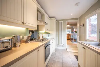 a kitchen with white cabinets and a stove top oven at Number 22, Leiston Road, Aldeburgh in Aldeburgh