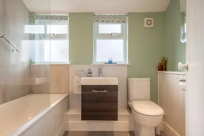 a bathroom with a toilet and a tub and a sink at Number 22, Leiston Road, Aldeburgh in Aldeburgh