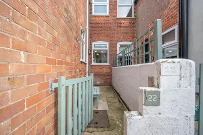 a brick building with a gate next to a brick wall at Number 22, Leiston Road, Aldeburgh in Aldeburgh