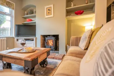 a living room with a table and a fireplace at Number 22, Leiston Road, Aldeburgh in Aldeburgh