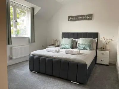 a bedroom with a large bed with two pillows at Iris Group Stay 8-BR Free Parking in Wenhaston