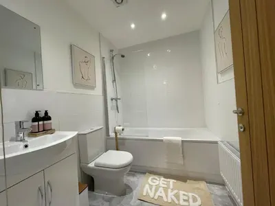 a bathroom with a tub and a toilet and a sink at Iris Group Stay 8-BR Free Parking in Wenhaston