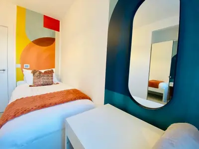 a bedroom with two beds and a mirror at Autumn House Cambridge free parking in Trumpington