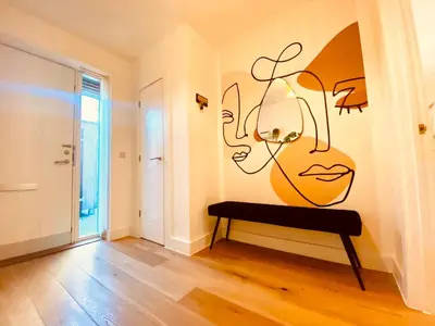a room with a wall with a painting of a woman at Autumn House Cambridge free parking in Trumpington