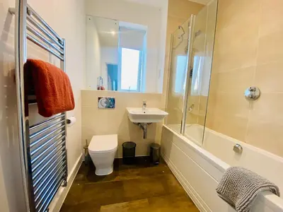 a bathroom with a toilet and a sink and a shower at Autumn House Cambridge free parking in Trumpington