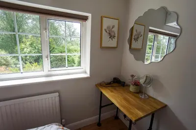 a room with a table and a mirror on the wall at Beautiful 2 Bed Home with Spacious Garden in Shephall