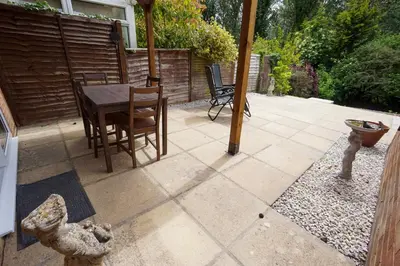 a patio with a table and chairs and an umbrella at Beautiful 2 Bed Home with Spacious Garden in Shephall