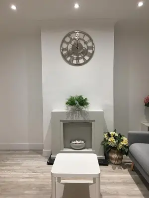 a living room with a clock and a fireplace at Spacious 3-bedroom Ipswich House with Parking in Ipswich