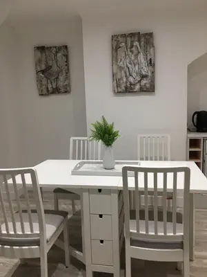 a white dining room table with two chairs and a potted plant at Spacious 3-bedroom Ipswich House with Parking in Ipswich