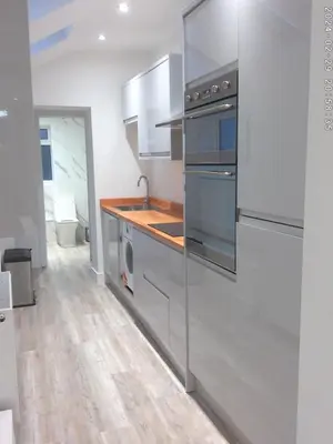 a kitchen with stainless steel appliances and wooden floors at Spacious 3-bedroom Ipswich House with Parking in Ipswich