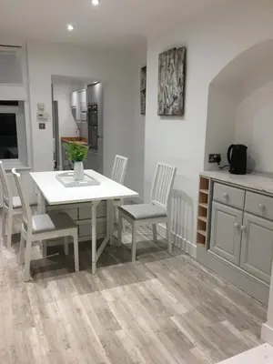 a kitchen with a white dining table and chairs at Spacious 3-bedroom Ipswich House with Parking in Ipswich