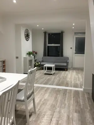 a living room with a table and a couch at Spacious 3-bedroom Ipswich House with Parking in Ipswich