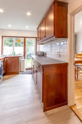 a kitchen with wooden cabinets and a counter top at Pass the Keys 3-Bedroom Home in Chelmsford Sleeps 7 in Chelmsford