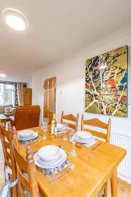 a dining room with a wooden table and chairs at Pass the Keys 3-Bedroom Home in Chelmsford Sleeps 7 in Chelmsford