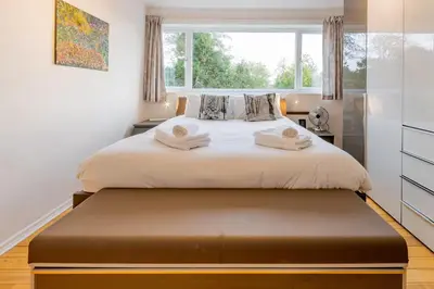 a bedroom with a bed with a large window at Pass the Keys 3-Bedroom Home in Chelmsford Sleeps 7 in Chelmsford