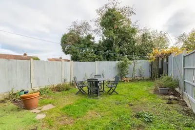 a backyard with a table and chairs and a fence at Pass the Keys 3-Bedroom Home in Chelmsford Sleeps 7 in Chelmsford