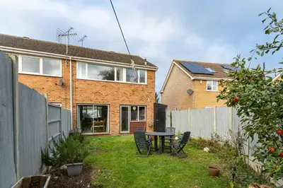 a backyard with a table and chairs and a house at Pass the Keys 3-Bedroom Home in Chelmsford Sleeps 7 in Chelmsford
