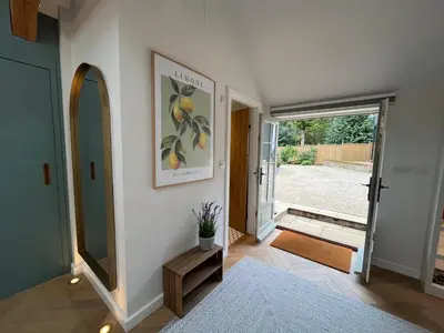 a hallway with a mirror and a door to a yard at Luxury Designer Boutique Annexe - Walk to Award Winning Pub in Sibton