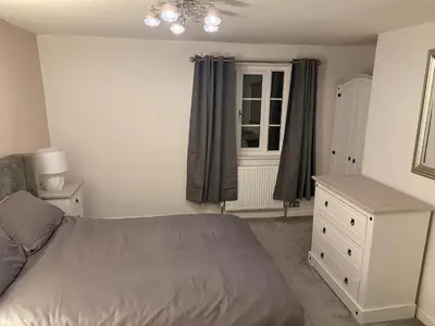 a bedroom with a bed and a dresser and a window at Cosy two bedroom house in eye Suffolk with parking near A140 in Eye