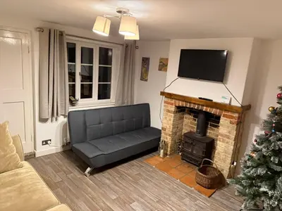 a living room with a couch and a fireplace at Cosy two bedroom house in eye Suffolk with parking near A140 in Eye