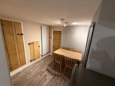 a dining room with a table and a refrigerator at Cosy two bedroom house in eye Suffolk with parking near A140 in Eye