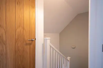 a hallway with a wooden door and a staircase at The Nook - Sizewell - Contractor Accommodation in Aldringham