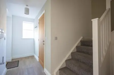 a hallway with stairs with a door and a stair case at The Nook - Sizewell - Contractor Accommodation in Aldringham