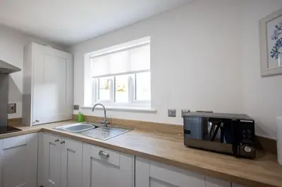 a kitchen counter with a microwave and a sink at The Nook - Sizewell - Contractor Accommodation in Aldringham